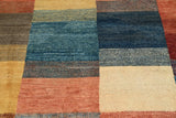 Orientmattor handknuten Gabbeh oriental matta in 177x109 cm with intricate patterns and warm colors, laid out on a wooden floor.